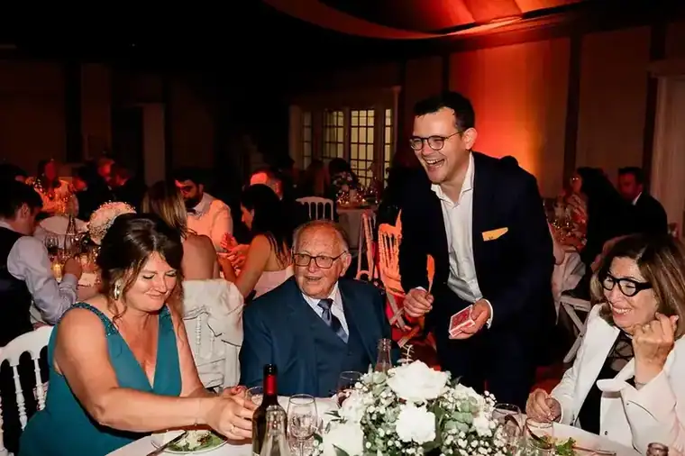 Magicien de mariage réalisant un tour devant des invités émerveillés 3