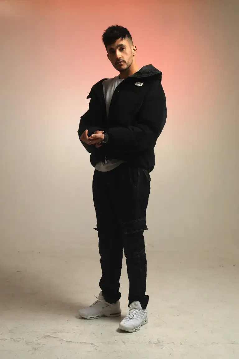 Kader Bueno en tenue noire posant en studio