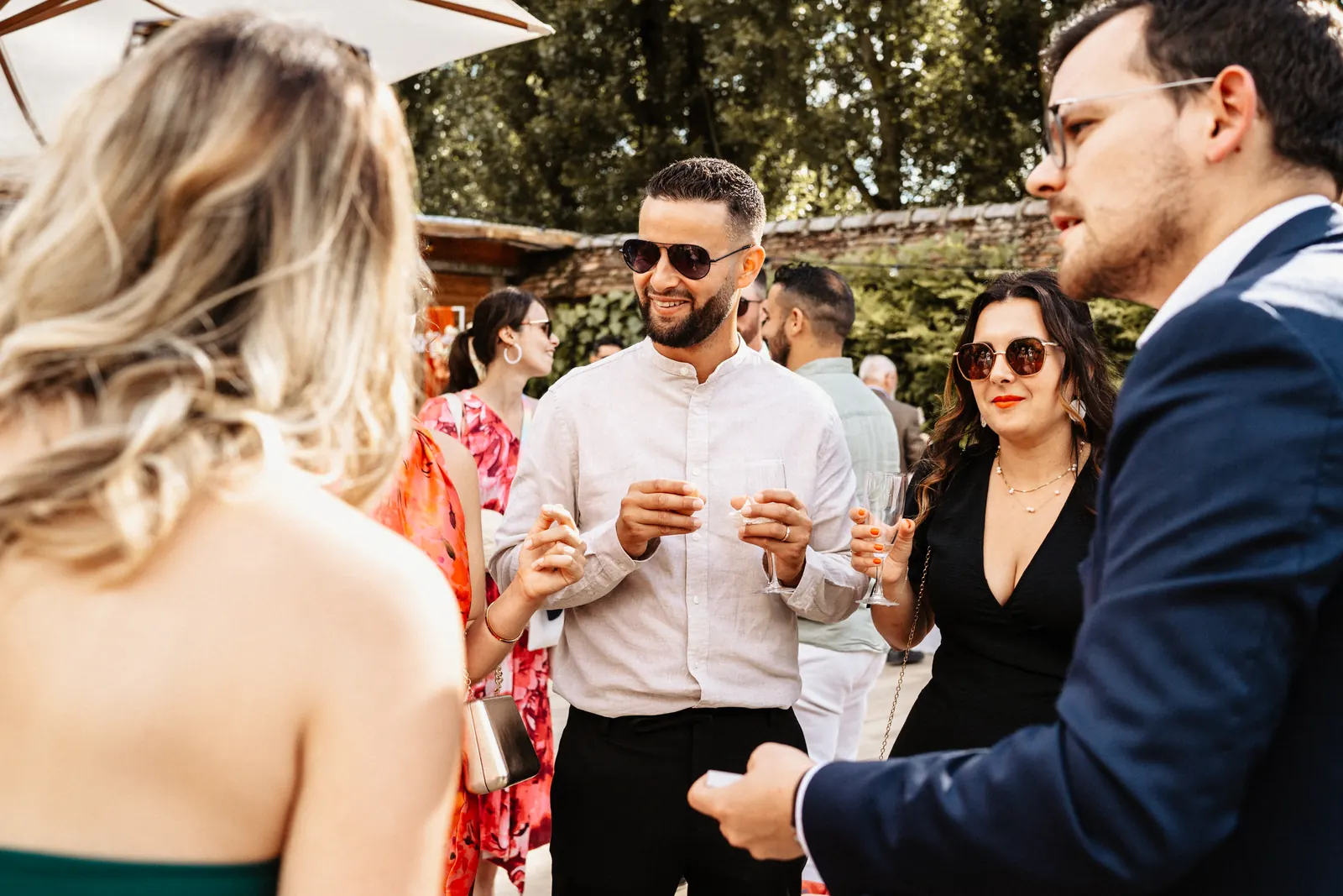 Des invités sourient pendant un tour de magie en extérieur