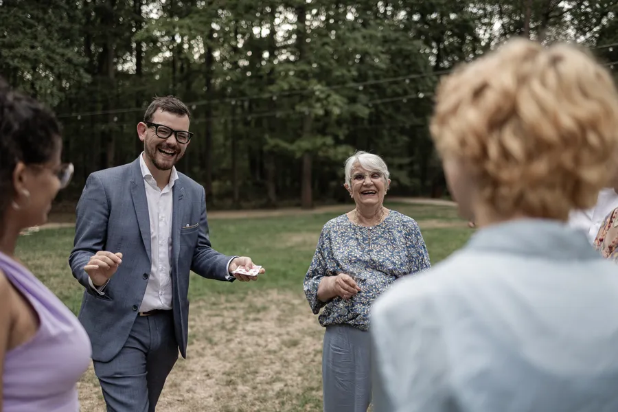 Alexis rit avec des invités pendant un tour de cartes au vin d’honneur