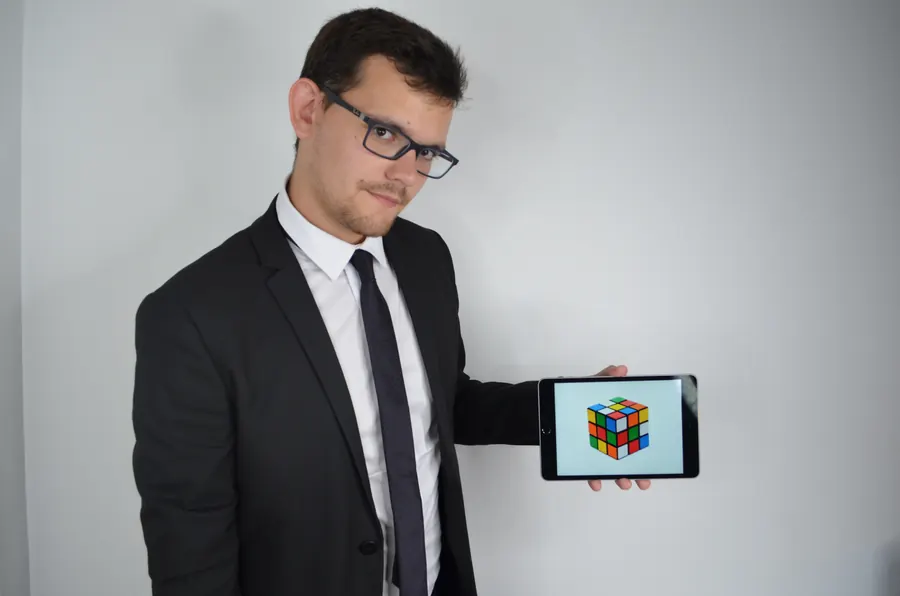 Alexis tient une tablette qui affiche un cube lors d’une démonstration