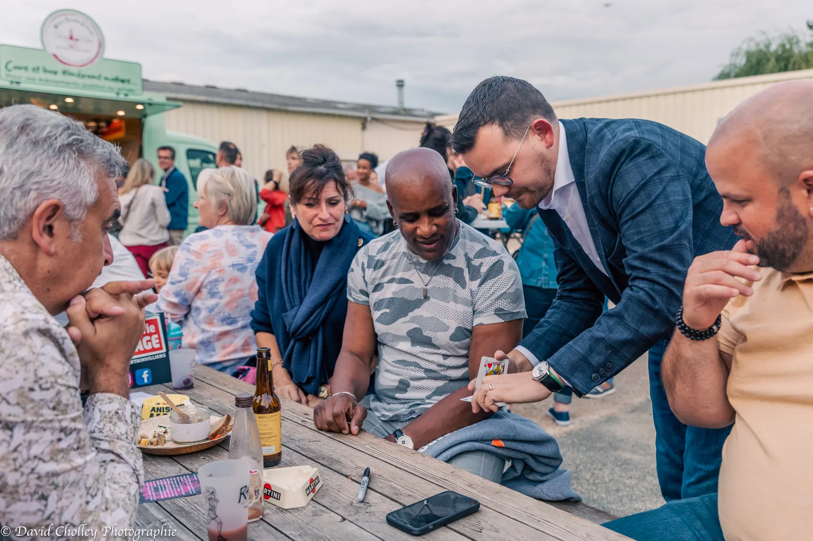 Des invités applaudissent à la fin d’un tour de magie lors d’une fête de famille