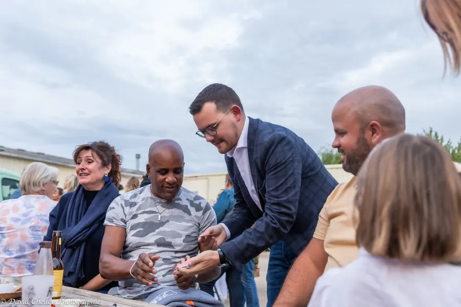 Alexis fait un tour de cartes à des amis lors d’une fête