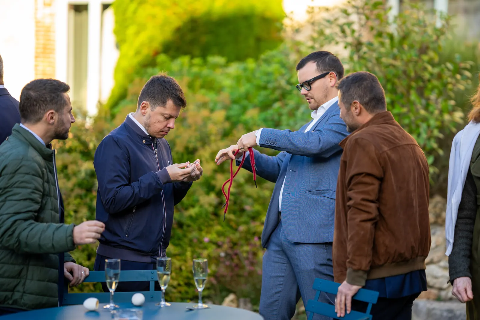 Alexis fait un tour de magie avec un ruban rouge pendant un cocktail