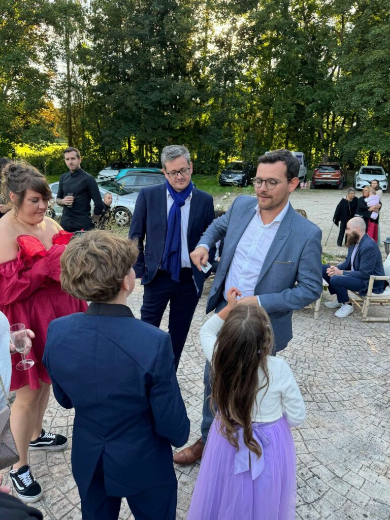 Magicien Paris réalisant un tour de magie sur scène devant un public émerveillé